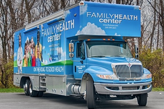 A mobile health clinic truck promoting rural health, with 