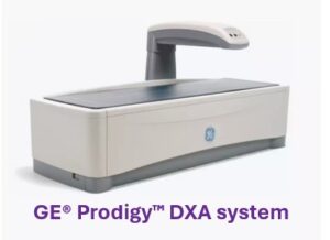 A GE Prodigy DXA system bone densitometer with a scanning arm over a flat examination table.