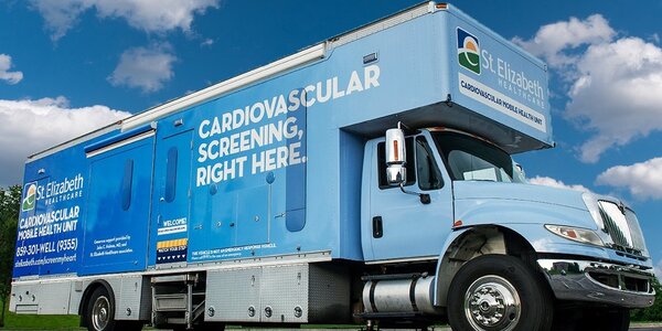 Light blue St. Elizabeth Healthcare mobile cardiovascular screening truck, similar in design to mobile audiology clinics.